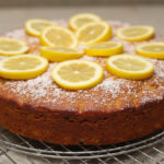 Finished Easy Lemon Poppy Seed cake with powdered sugar and lemon garnish.